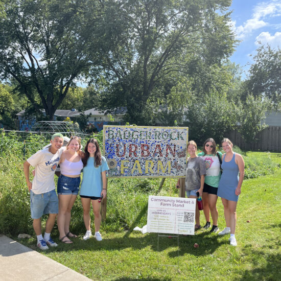 students in front of Badger Rock Community Garden sign